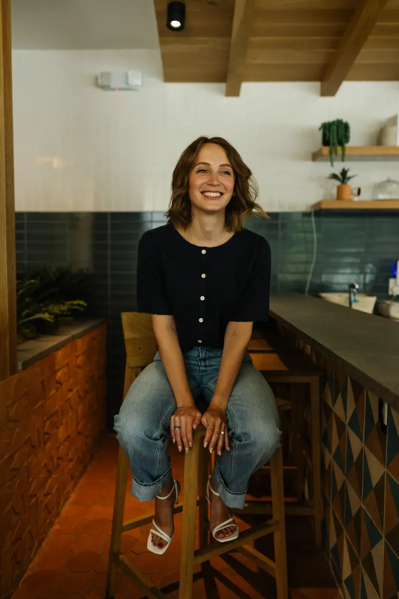 Anna sitting on a chair, smiling.